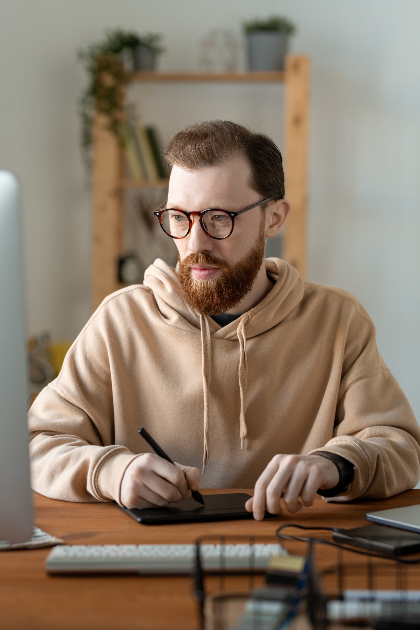 Young contemporary serious freelance designer using touchpad and stylus